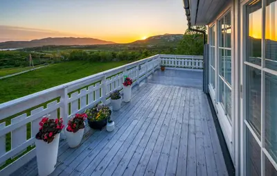 a porch with potted plants on a house with the sunset at Awesome Home In Ånneland With Wifi in Ånneland