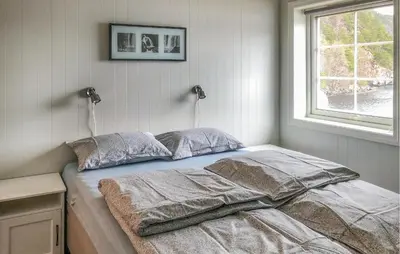 a bedroom with a bed with two pillows and a window at 4 Bedroom Awesome Home In Tørvikbygd in Tyrvikbygd