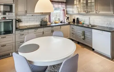 a kitchen with a white table and chairs at 4 Bedroom Awesome Home In Tørvikbygd in Tyrvikbygd