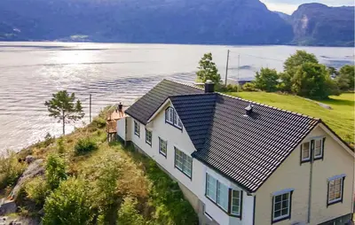 a house on a hill next to a body of water at 4 Bedroom Awesome Home In Tørvikbygd in Tyrvikbygd