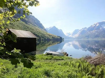 a small shack sitting on the shore of a lake at Flo Bellevue in Stryn