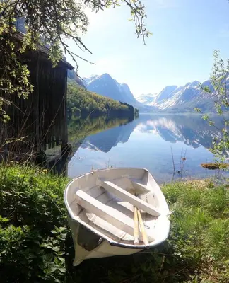a boat sitting on the side of a lake at Flo Bellevue in Stryn