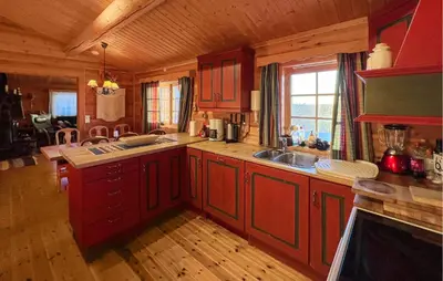 a large kitchen with red cabinets in a cabin at Awesome Home In Venabygd With Sauna in Venabygd