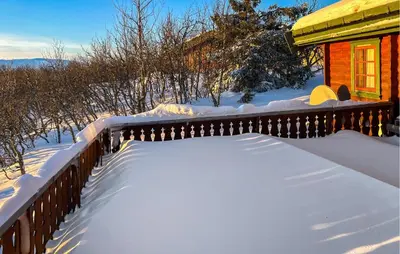 a fence covered in snow next to a house at Awesome Home In Venabygd With Sauna in Venabygd