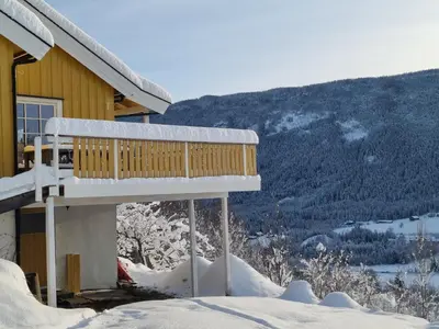 a snow covered porch of a house with a mountain at Solhaug in Torpo