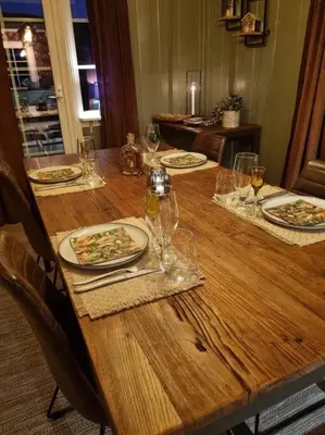 a wooden table with plates of food and wine glasses at Solhaug in Torpo