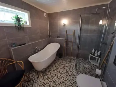 a bathroom with a tub and a shower and a sink at Solhaug in Torpo