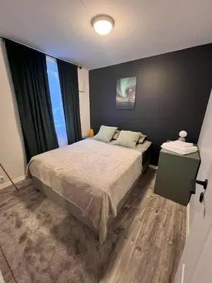a bedroom with a bed and a large window at Spacious and Beautiful Apartment in Bergen with free parking in Bergen
