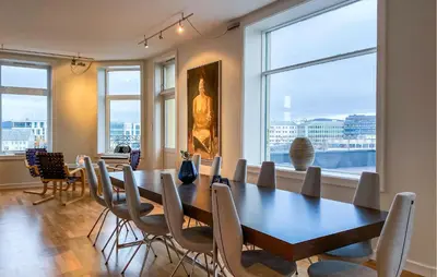 a dining room with a table and chairs and windows at 1 Bedroom Stunning Apartment In Ålesund in Ålesund