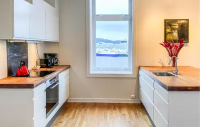a kitchen with white cabinets and a window at 1 Bedroom Stunning Apartment In Ålesund in Ålesund