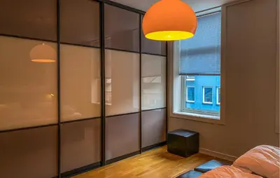 a bedroom with glass walls and a window and a bed at 1 Bedroom Stunning Apartment In Ålesund in Ålesund