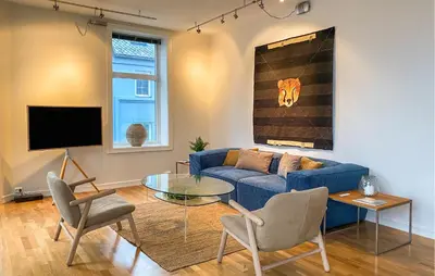 a living room with a blue couch and a glass table at 1 Bedroom Stunning Apartment In Ålesund in Ålesund