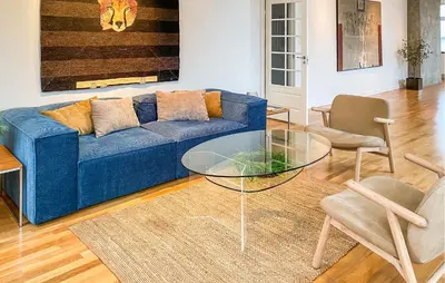 a living room with a blue couch and a glass table at 1 Bedroom Stunning Apartment In Ålesund in Ålesund