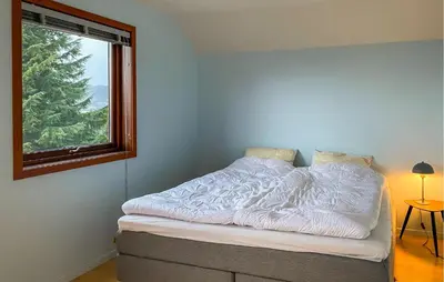a bed in a room with a window at Pet Friendly Home In Ålesund in Ålesund