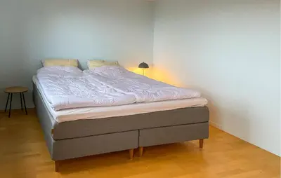 a bed in a room with a white wall at Pet Friendly Home In Ålesund in Ålesund