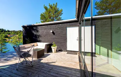 a house with a deck with a chair and a bench at 4 Bedroom Lovely Home In Skodje in Skodje