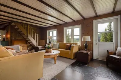 a large living room with couches and a staircase at Your Ideal Getaway Awaits in This Charming Cabin Retreat in Nord Torpa