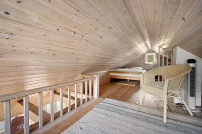 a room with a wooden ceiling with a bed and a desk at Sjötun Fjord Cabin, with boat in Stanghelle