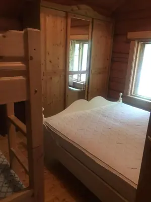 a bedroom with a bunk bed and two windows at Gamlestogo, Rønlund Hyttepark in Ron