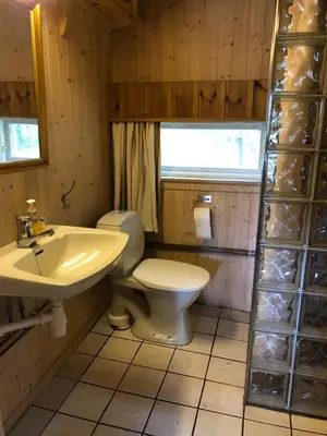 a bathroom with a toilet and a sink at Gamlestogo, Rønlund Hyttepark in Ron