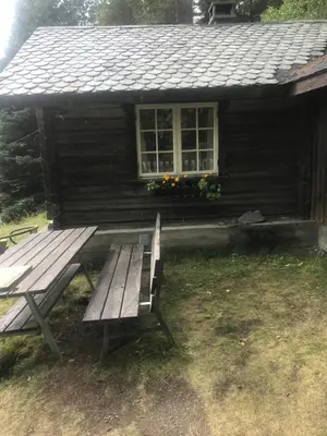 a wooden bench sitting in front of a cabin at Gamlestogo, Rønlund Hyttepark in Ron