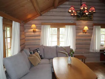 a living room with a couch and a table at Gamlestogo, Rønlund Hyttepark in Ron