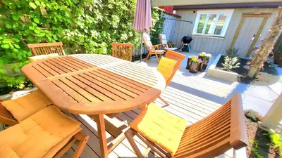 a wooden table and chairs on a patio at Mercury House, Cathedral View ! Free Parking ! in Trondheim