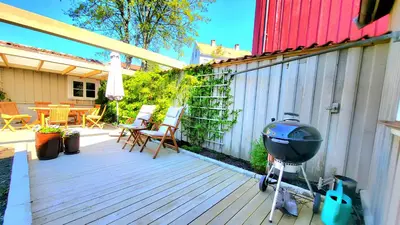 a grill on a wooden deck next to a fence at Mercury House, Cathedral View ! Free Parking ! in Trondheim