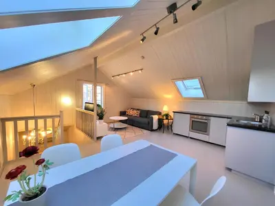 a kitchen and a living room with a table and a couch at Mercury House, Cathedral View ! Free Parking ! in Trondheim