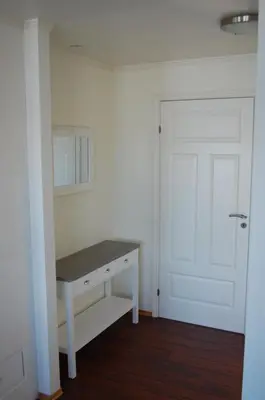 a white room with a desk and a white door at Feriehus nede ved sjøen inntil 6 pers in Vestnes