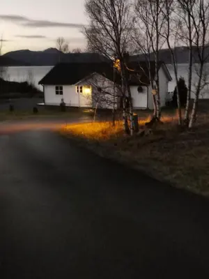 a house on the side of a road next to a house at Feriehus nede ved sjøen inntil 6 pers in Vestnes
