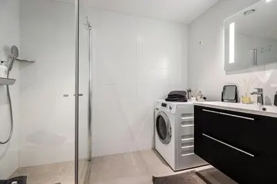 a bathroom with a washing machine and a shower at New penthouse apartment with sea view in Bergen centrum in Bergen