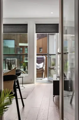 a living room with a table and a glass door at New penthouse apartment with sea view in Bergen centrum in Bergen