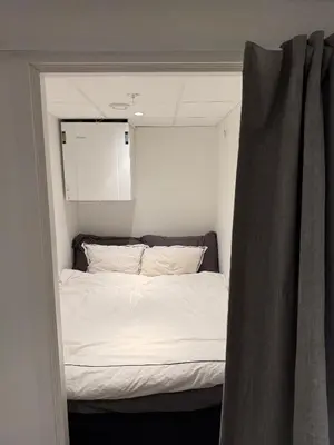 a bed in a small room with a window at New penthouse apartment with sea view in Bergen centrum in Bergen