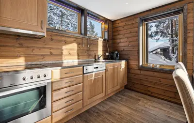 a kitchen with wooden cabinets and a sink and a stove at Beautiful Apartment In Meråker in Meråker