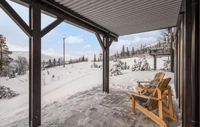 a porch covered in snow with chairs on it at Beautiful Apartment In Meråker in Meråker