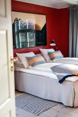 two beds in a room with a red wall at Hotel Aak in Åndalsnes