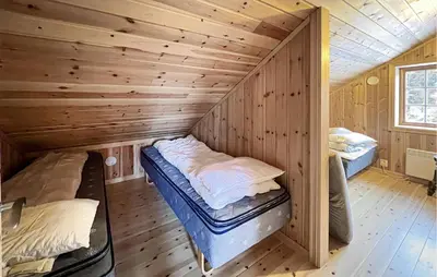 a room with two beds in a wooden cabin at 2 Bedroom Nice Home In Aust- Torpa in Aust-Torpa