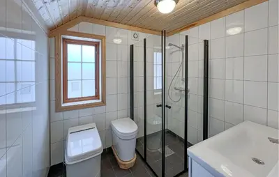 a bathroom with a toilet and a shower and a sink at 2 Bedroom Nice Home In Aust- Torpa in Aust-Torpa