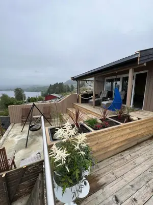 a wooden deck with plants on a house at Turer, avslapping, jakt, fiske, utsikt in Etnesjøen