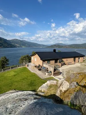 a house on the shore of a body of water at Turer, avslapping, jakt, fiske, utsikt in Etnesjøen