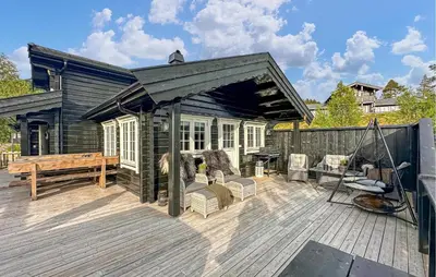 a wooden deck with a bench and a house at 3 Bedroom Gorgeous Home In Bjorli in Bjorli