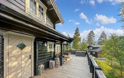a wooden deck next to a house with a garage at 3 Bedroom Gorgeous Home In Bjorli in Bjorli
