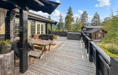 a wooden deck with a picnic table and a house at 3 Bedroom Gorgeous Home In Bjorli in Bjorli