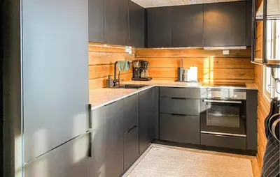a kitchen with gray cabinets and wooden walls at 3 Bedroom Gorgeous Home In Bjorli in Bjorli