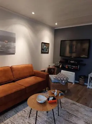 a living room with a couch and a flat screen tv at Rorbu i Austevoll med 3 soverom og mulighet for båtleie in Kolbeinsvik