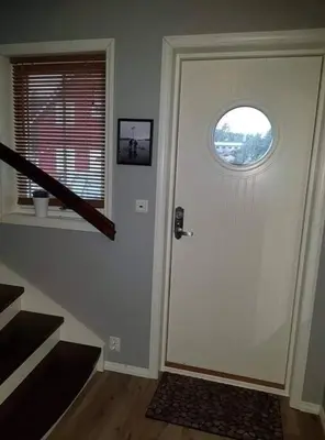 a hallway with a door with a round window at Rorbu i Austevoll med 3 soverom og mulighet for båtleie in Kolbeinsvik