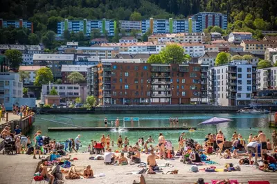 a group of people on a beach in the water at Modern apartment in the heart of Bergen in Bergen