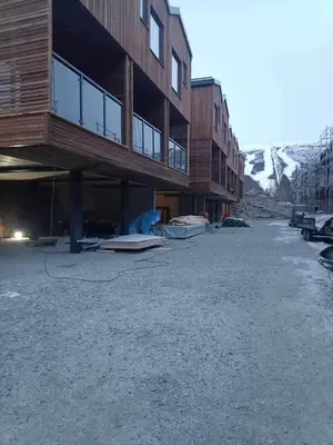 an empty parking lot in front of a building at Hyt leilighet med 2 soverom in Bjorli