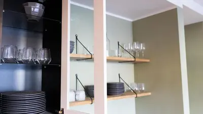 a pantry with plates and glasses on shelves at Elegant Urban Apartment in Bergen